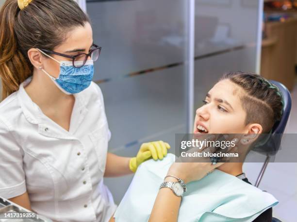 young woman having toothache at dentist - painful lips stock pictures, royalty-free photos & images