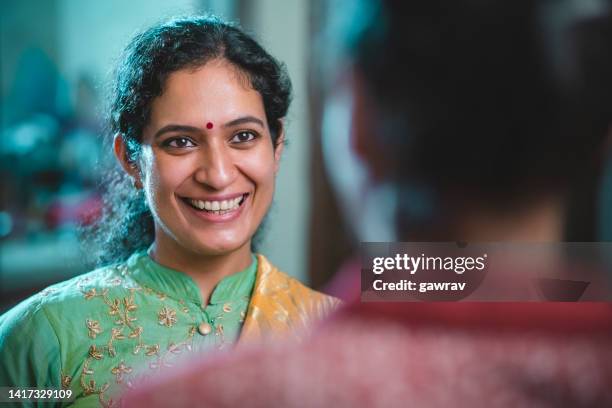 mid-adult woman gossips happily with a young woman at home. - indian aunt stock pictures, royalty-free photos & images