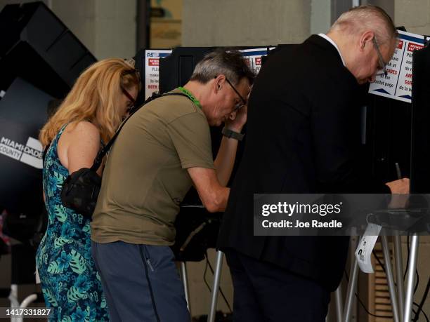 Florida Helen Carr and Michael Oliveira fill out their ballots as they vote at a polling station set up in a fire station on August 23, 2022 in Miami...