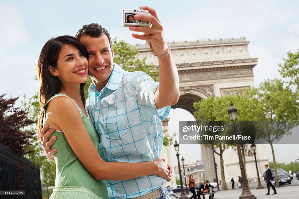 Couple Using Digital Camera Outside Arc de Triomphe