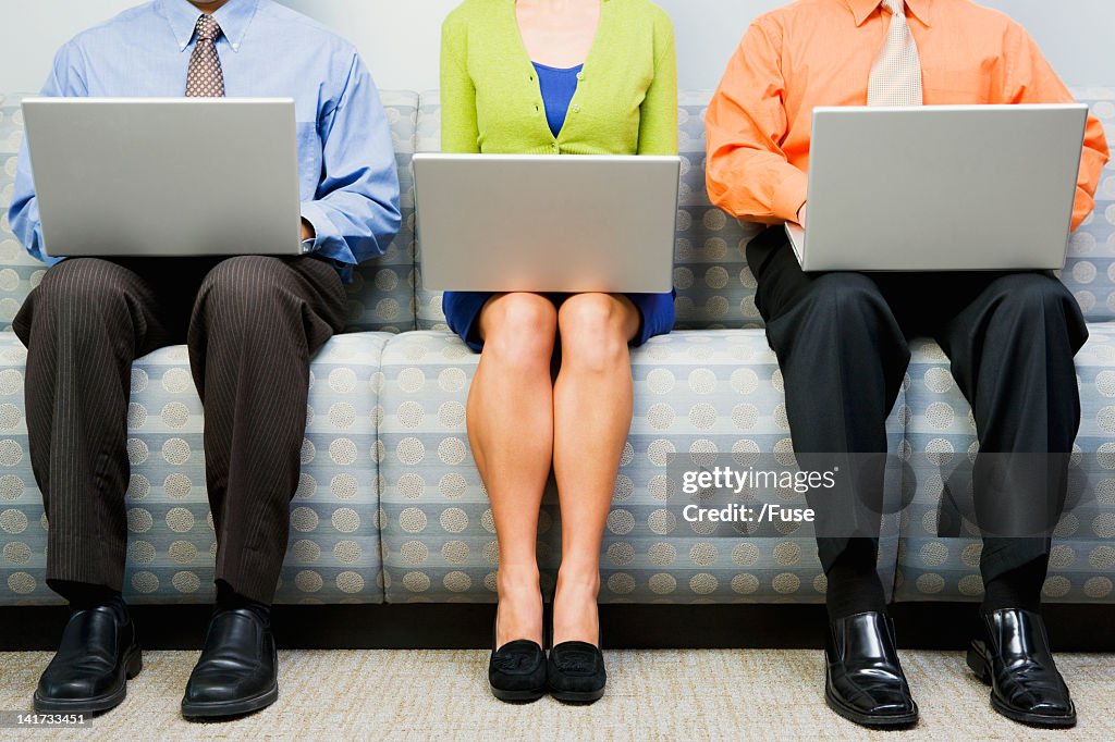 Businesspeople using laptops