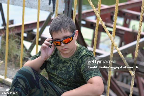 portrait of a teenage boy wearing camouflage clothing. - military uniform close up stock pictures, royalty-free photos & images