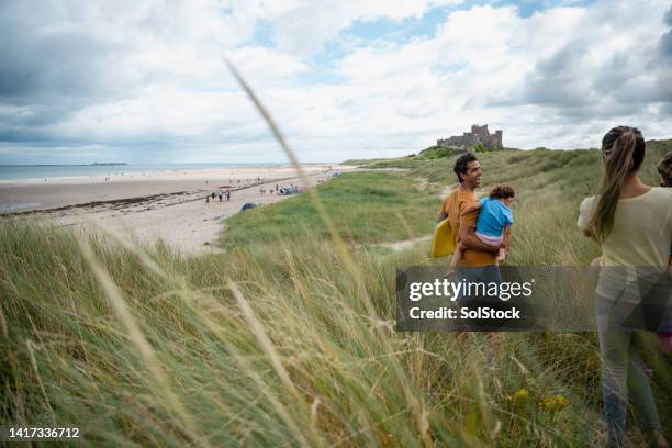 famiglia che visita la spiaggia - northumberland foto e immagini stock