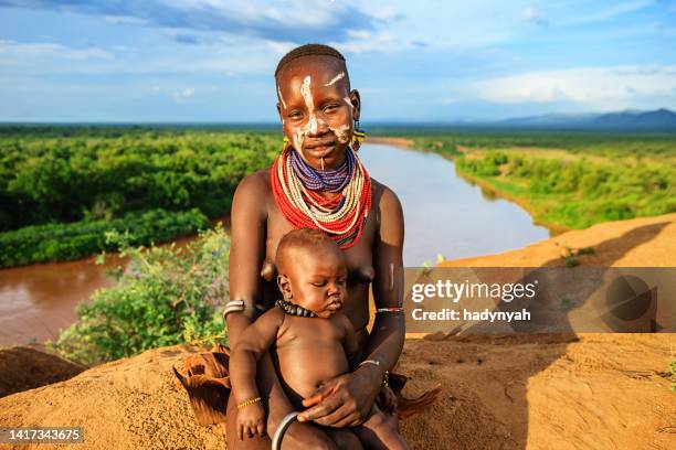 woman from karo tribe holding her baby, ethiopia, africa - omo valley stock pictures, royalty-free photos & images