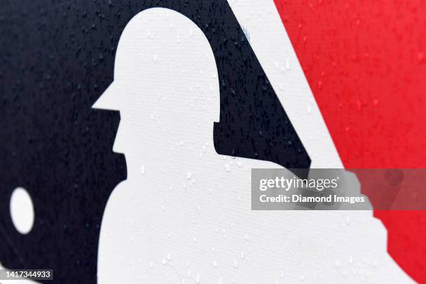 Closeup view of the Major League Baseball logo as rain falls prior to a game between the Chicago White Sox and the Cleveland Guardians at Progressive...