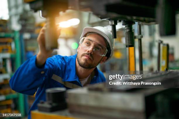 worker in factory - gafas protectoras fotografías e imágenes de stock