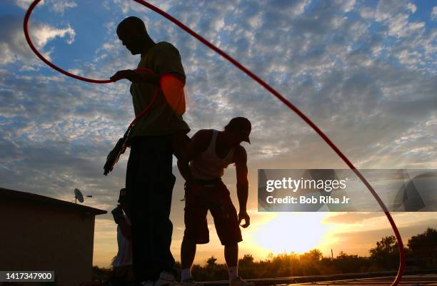 Roofing construction workers arrive at work before sunrise at 4:30am to beat the extreme heat by mid-morning, August 8, 2003 in Needles, California.