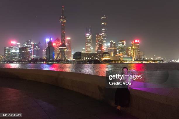 Tourists visit the Bund with the skyline of Pudong in the background on August 22, 2022 in Shanghai, China. Shanghai will switch off decorative...