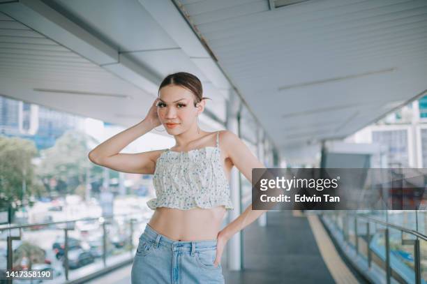 portrait asian lgbtqia transgender female looking at camera smiling on bridge in city - chinese indonesians stock pictures, royalty-free photos & images