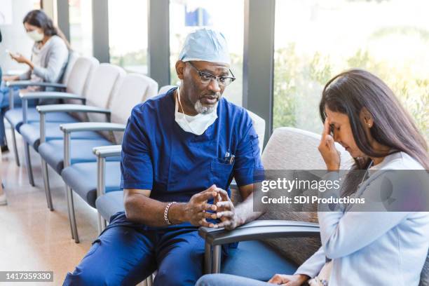 la paciente se pone las manos en la cabeza preocupada - malas noticias fotografías e imágenes de stock