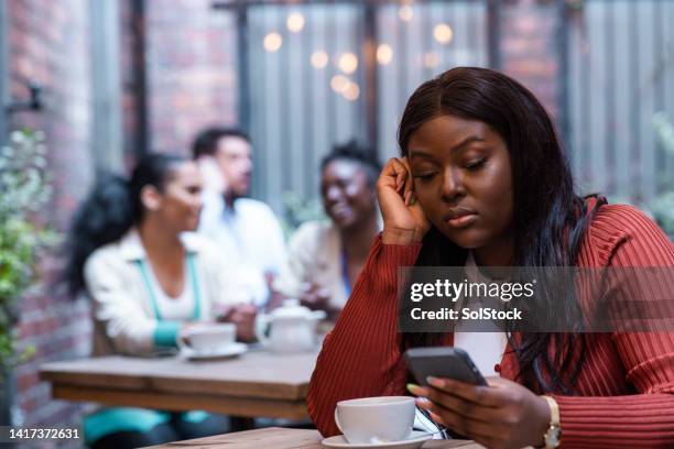 scrolling through her phone at a cafe - relationship difficulties stock pictures, royalty-free photos & images