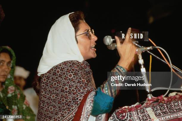 Profile of Pakistani Prime Minister Benazir Bhutto as she speaks into microphones during a campaign in the Pakistani General Election, Karachi,...