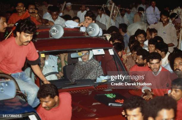 View of Pakistani Prime Minister Benazir Bhutto , escorted by supporters, as she campaigns during the Pakistani General Election, Karachi, Pakistan,...