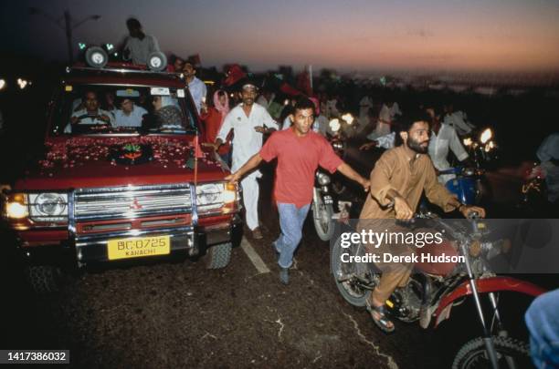 View of Pakistani Prime Minister Benazir Bhutto , escorted by supporters, as she campaigns during the Pakistani General Election, Karachi, Pakistan,...