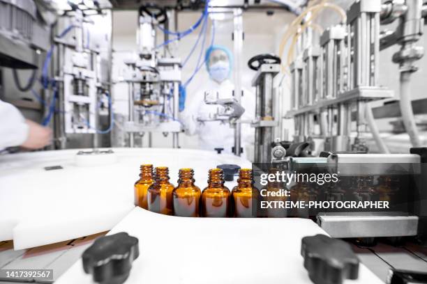 botellas farmacéuticas dispuestas correctamente durante la fabricación en una industria farmacéutica - fábrica farmacéutica fotografías e imágenes de stock