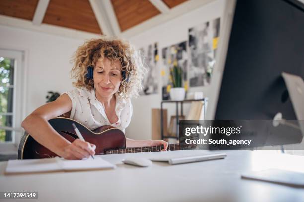 frau lernt gitarre spielen - liedermacher stock-fotos und bilder