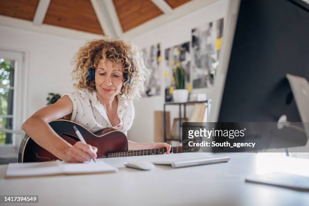 woman learning to play guitar - songwriter stock pictures, royalty-free photos & images