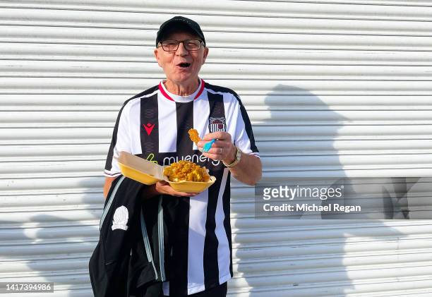 Grimsby Town supporter eats food outside the stadium prior to the Carabao Cup Second Round match between Grimsby Town and Nottingham Forest at...