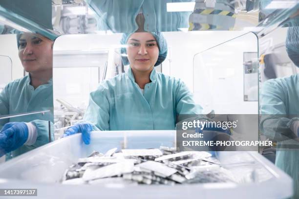 un employé pharmaceutique vu tenant une boîte avec de nombreuses plaquettes thermoformées dans une pièce spéciale - équipement médical photos et images de collection