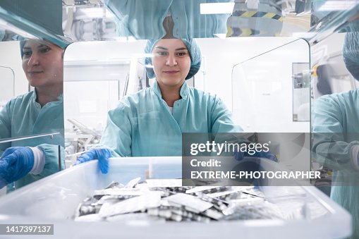 Pharmaceutical employee seen holding a box with numerous blister packs in a special room Pharmaceutical employee seen holding a box with numerous blister packs in a special room