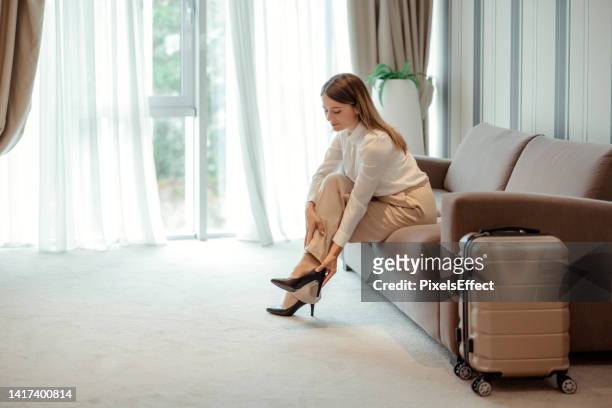 businesswoman taking off her shoes - high heels pain stock pictures, royalty-free photos & images