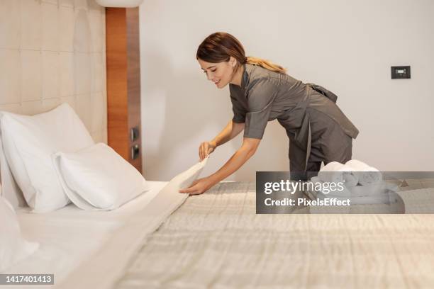 maid making the bed at a hotel - hotel housekeeping stock pictures, royalty-free photos & images