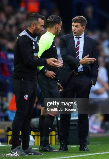 Steven Gerrard, Manager of Aston Villa interacts with Fourth Official Thomas Kirk during the Carabao Cup Second Round match between Bolton Wanderers...