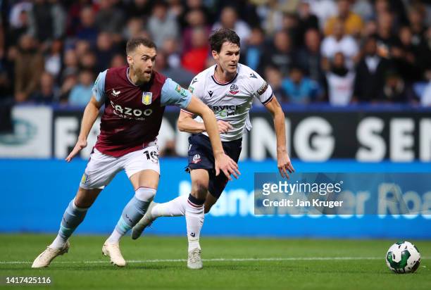 Calum Chambers of Aston Villa battles for possession with Kieran Lee of Bolton Wanderers during the Carabao Cup Second Round match between Bolton...