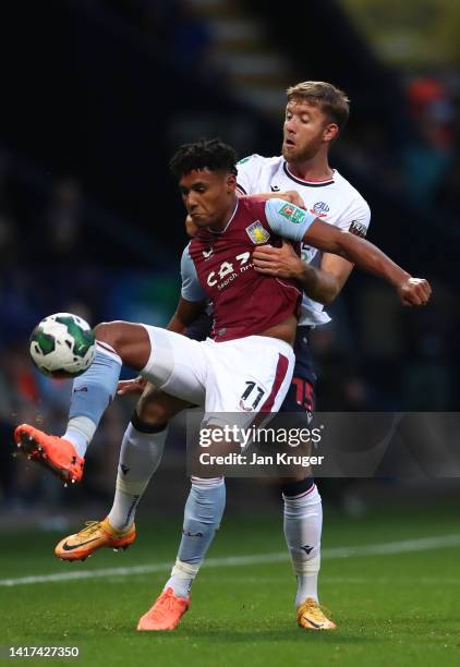 Ollie Watkins of Aston Villa battles with Will Aimson of Bolton Wanderers during the Carabao Cup Second Round match between Bolton Wanderers and...