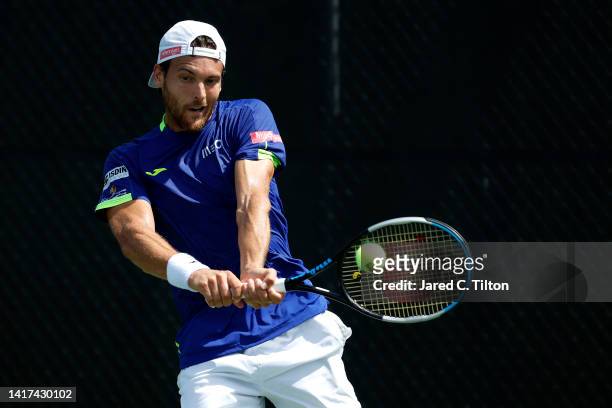 Joao Sousa of Portugal returns a shot from Laslo Djere of Serbia during their second round match on day four of the Winston-Salem Open at Wake Forest...