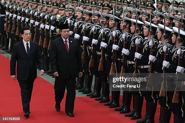 Chinese President Hu Jintao accompanies Indonesia's President Susilo Bambang Yudhoyono to view a guard of honour during a welcoming ceremony inside...