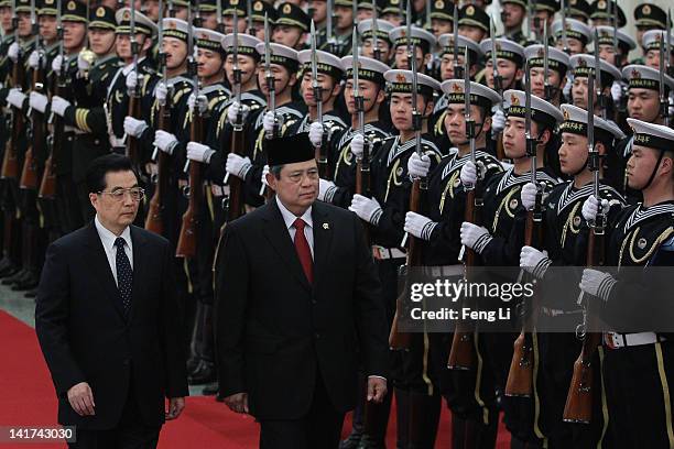 Chinese President Hu Jintao accompanies Indonesia's President Susilo Bambang Yudhoyono to view a guard of honour during a welcoming ceremony inside...