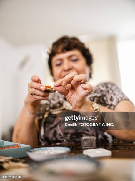 senior disabled latin woman doing arts and craft - arts patient stock pictures, royalty-free photos & images