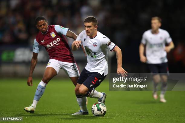 Declan John of Bolton Wanderers competes for the ball with Leon Bailey of Aston Villa during the Carabao Cup Second Round match between Bolton...