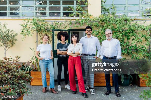 multiracial business colleagues standing together outside office building - gruppenbild stock-fotos und bilder