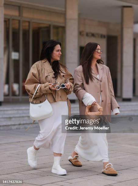 Lou Beyer wearing Saint Laurent white shades, beige cropped Acne Studios jacket, long white cotton COS dress, white leather Prada Cleo bag and white...