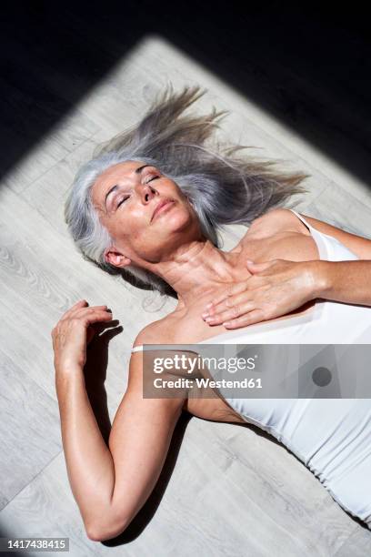 mature woman with hand on chest resting under sunlight - hand on chest stock pictures, royalty-free photos & images