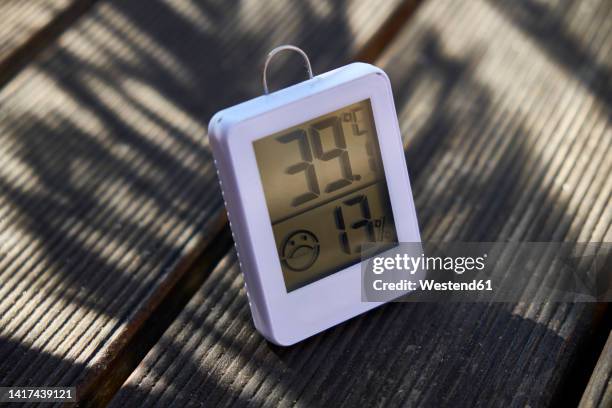 digital thermometer on wooden bench - thermomètre à affichage digital photos et images de collection