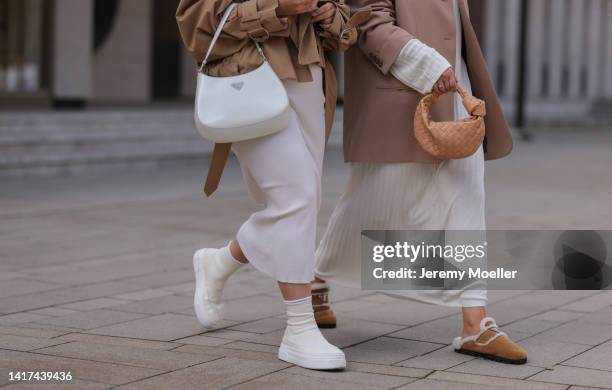 Lou Beyer wearing Saint Laurent white shades, beige cropped Acne Studios jacket, long white cotton COS dress, white leather Prada Cleo bag and white...