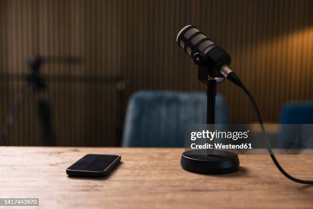 smart phone by microphone on desk in recording studio - podcasting mic stock pictures, royalty-free photos & images