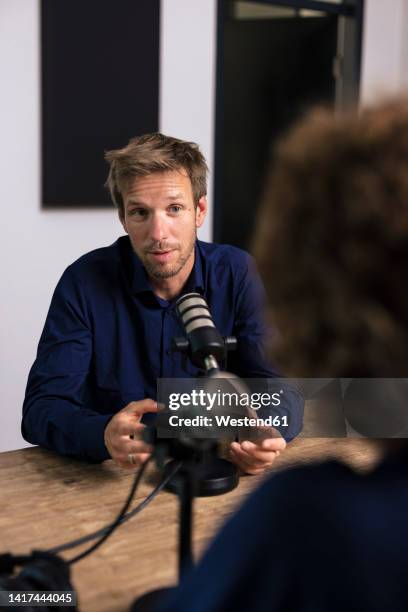 man talking with guest in recording studio - radio presenters stock pictures, royalty-free photos & images