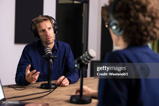 guest wearing headset talking with presenter in radio station - radio dj stock pictures, royalty-free photos & images