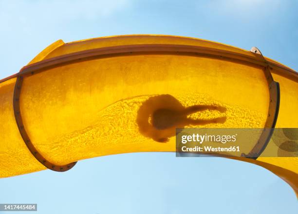 silhouette of person sliding down water slide - water slide stock pictures, royalty-free photos & images