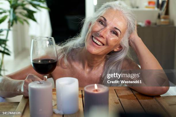 happy woman with red wine in bathroom - bañando bebe fotografías e imágenes de stock