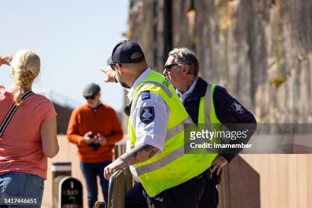 secirity quard showing tourists direction in city, background with copy space - police australia stock pictures, royalty-free photos & images