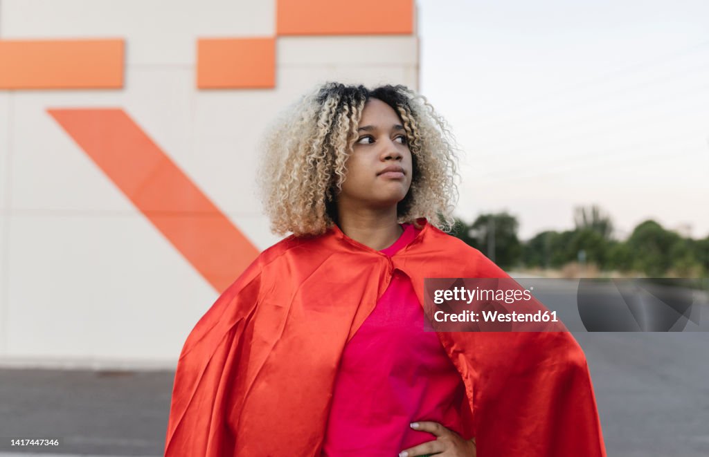 Thoughtful woman with blond hair wearing cape