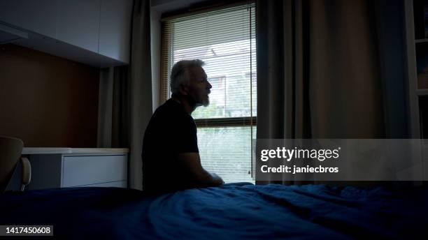 tired, mature man getting up early in the morning. - head in hands silhouette stock pictures, royalty-free photos & images