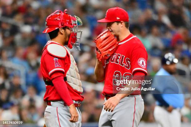 Kurt Suzuki and Tucker Davidson of the Los Angeles Angels meet on the mound during the first inning against the Tampa Bay Rays at Tropicana Field on...