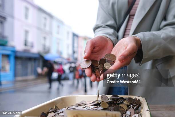 woman dropping old coins in tray - flip stock pictures, royalty-free photos & images