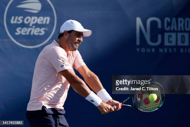 Steve Johnson of United States returns a shot to Pedro Martinez of Spain during their second round match on day four of the Winston-Salem Open at...